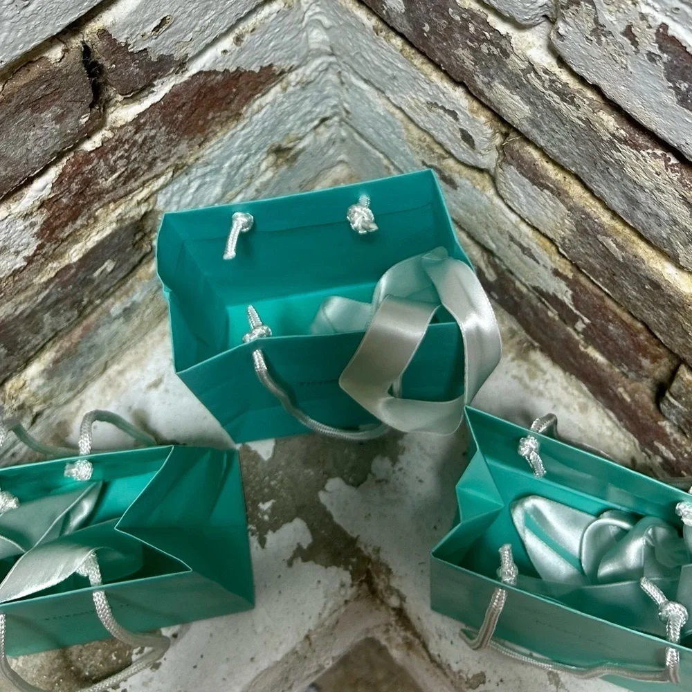 Set of three original Tiffany & Co blue bags and white ribbons.